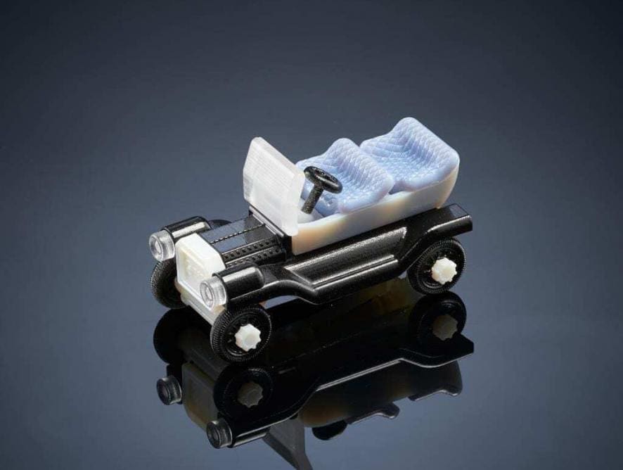Carrinho de brinquedo impresso em impressora 3D. Carcaça na cor preta e bancos da na cor branca. Carro conversível. Modelo antigo.