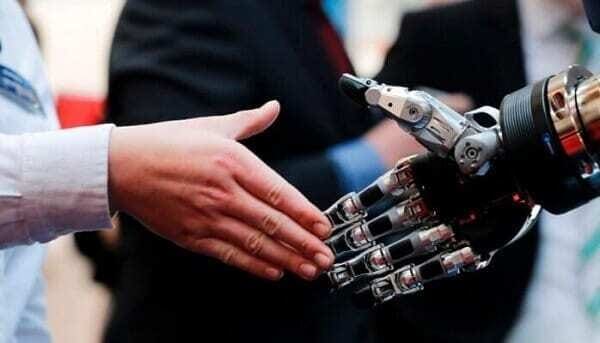 profissional da industria 4.0 com mão estendida para cumprimentar mão robótica.