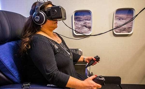 Mulher usando óculos de realidade aumentada fazendo tratamento em ambiente parecido com interior de avião.
